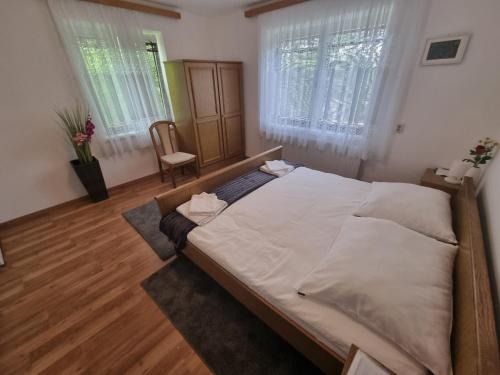 a large bed in a room with two windows at Pension DonauBlick Grein 1 , Spitzfeldstr 1 in Grein