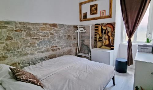 una camera con letto e muro di mattoni di Casa Bianca - 2 Bedroom Design Apartment a Trieste