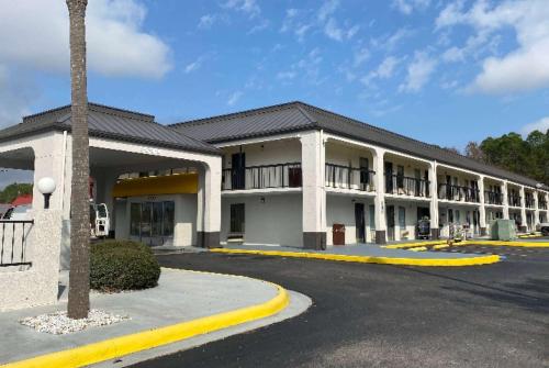 a large building with a parking lot in front of it at Days Inn by Wyndham Moss Point Pascagoula in Moss Point