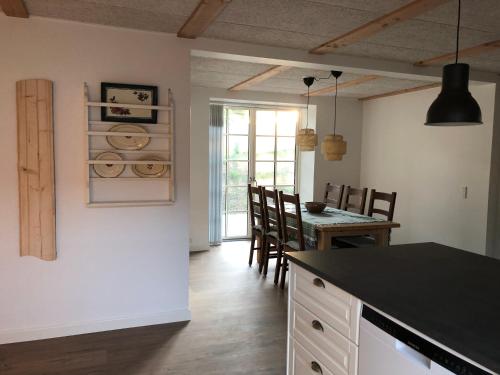 a kitchen and dining room with a table and chairs at Nordgården - ferie på landet in Skibby