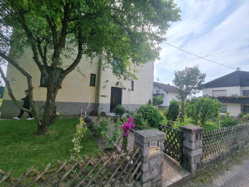a fence in front of a house with a tree at Pension DonauBlick Grein 1 , Spitzfeldstr 1 in Grein
