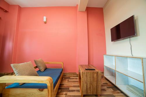 ein Zimmer mit einem Bett und einem Fernseher an der Wand in der Unterkunft Subedi Apartment in Pokhara