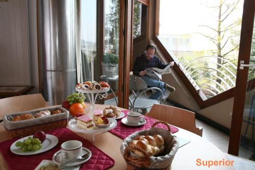 a man sitting in a room with a table with food at Lugano Savosa Youth Hostel in Lugano