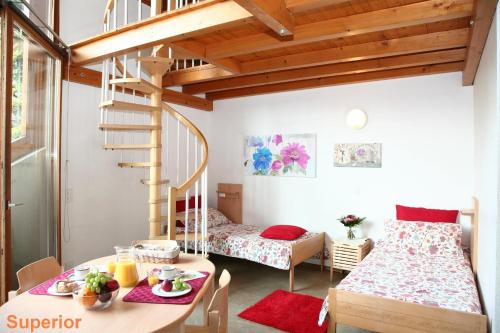 ルガノにあるLugano Savosa Youth Hostelのベッド1台、テーブル、階段が備わる客室です。
