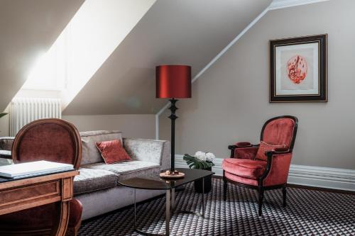 a living room with a couch and two chairs at Althoff Grandhotel Schloss Bensberg in Bergisch Gladbach