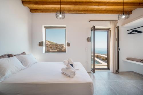 a bedroom with a bed with a view of the ocean at Petrias Pool House in Serifos Chora