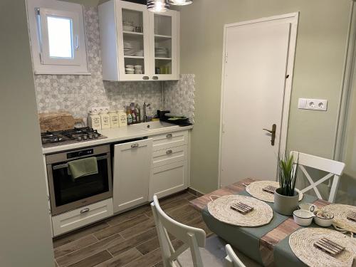 uma cozinha com uma mesa e um fogão em Szemes Villa em Balatonszemes