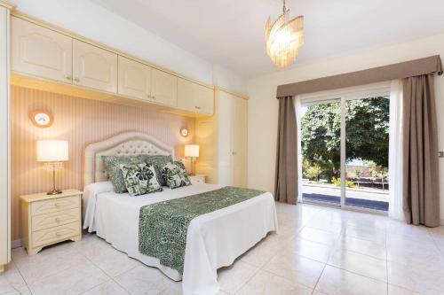 アカンティラド・デ・ロス・ヒガンテスにあるVilla Las Floresのベッドルーム(白いベッド1台、大きな窓付)