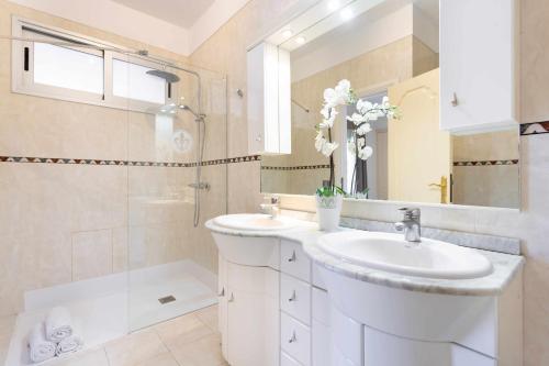 ein weißes Bad mit einem Waschbecken und einer Dusche in der Unterkunft Villa Las Flores in Acantilado de los Gigantes