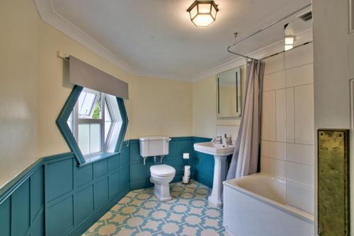 a bathroom with a toilet and a sink and a tub at Ashfield Place Farm by Group Retreats in Stowmarket