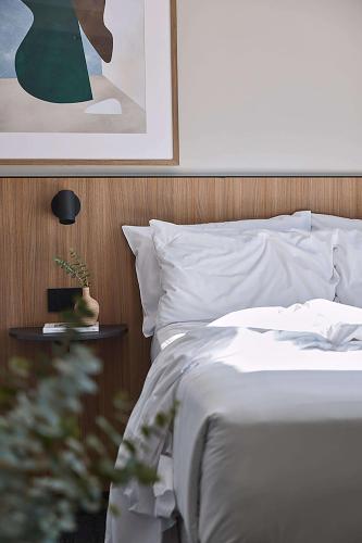 a bedroom with a white bed with a wooden headboard at Pensione Hotel Perth in Perth