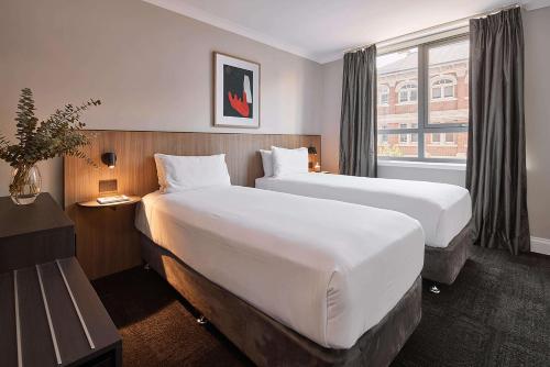 a hotel room with two beds and a window at Pensione Hotel Perth in Perth