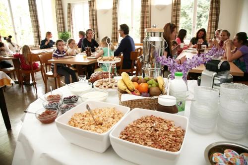 a table with food on it with people sitting at tables at Lugano Savosa Youth Hostel in Lugano
