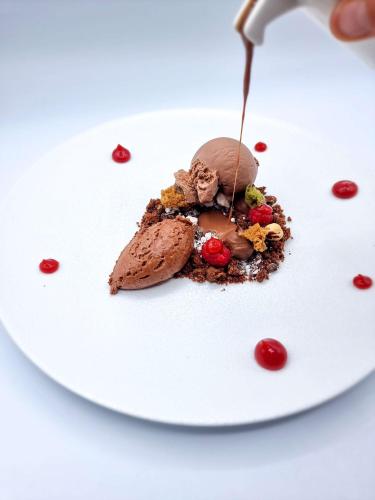 a piece of chocolate ice cream on a plate with a spoon at Best Western Plus Hotel & Restaurant Les Humanistes Colmar Nord in Sélestat