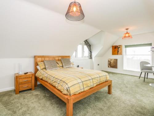 a bedroom with a bed and a chair in it at Seaview in Lowestoft