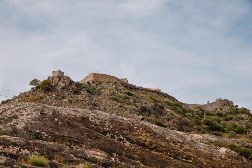 a hill with a castle on top of it at Chalês - Maria Alva in Marialva