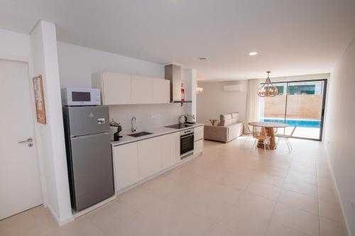 a kitchen with a refrigerator and a table in it at Chalês - Maria Alva in Marialva