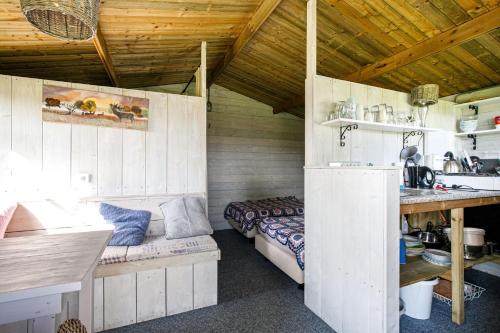 Camping De Nieuwe Hof في أوتيرلو: غرفة صغيرة بها سرير ومطبخ