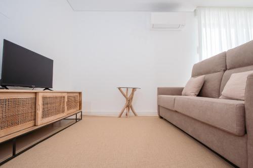 a living room with a couch and a flat screen tv at Chalês - Maria Alva in Marialva
