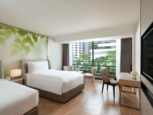 um quarto de hotel com duas camas e uma varanda em Mövenpick BDMS Wellness Resort Bangkok em Banguecoque