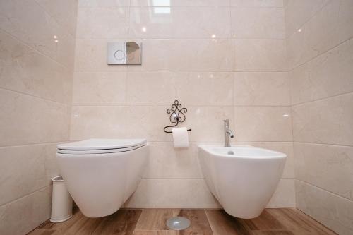 a white bathroom with a toilet and a bidet at Chalês - Maria Alva in Marialva