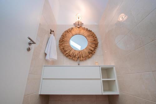 a bathroom with a mirror and a white shelf at Chalês - Maria Alva in Marialva