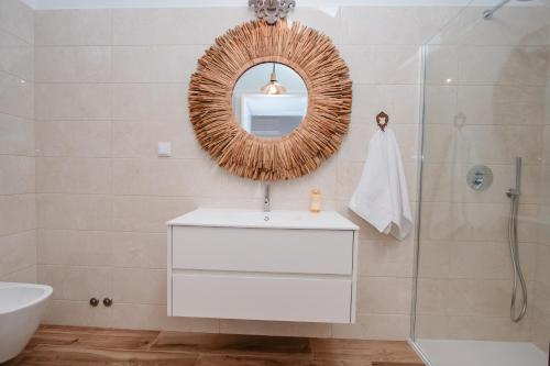 a bathroom with a mirror and a sink and a tub at Chalês - Maria Alva in Marialva