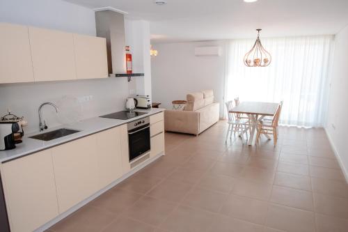 a kitchen with white cabinets and a table in a room at Chalês - Maria Alva in Marialva
