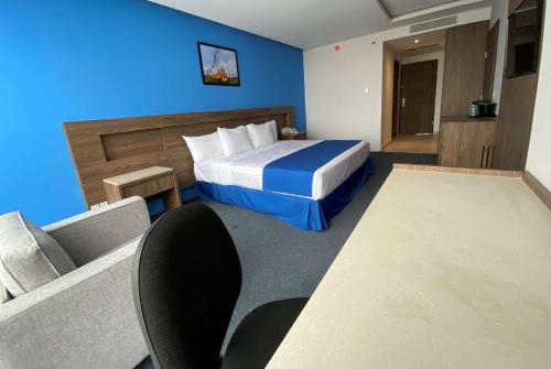 a hotel room with a bed and a couch at Wyndham Puebla Angelopolis in Puebla