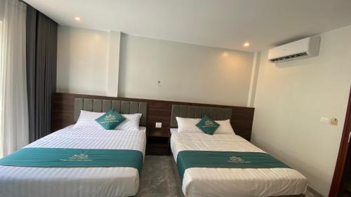 two beds in a hotel room withacers at Tuần Châu HQT in Ha Long