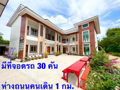 a house with a red bench in front of it at โรงแรมบ้านครูตุ้ม เชียงคาน เลย Baankrutoom Hotel Chiangkhan Loei in Chiang Khan