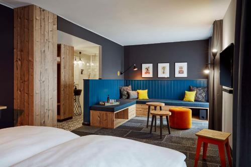 une chambre d'hôtel avec un lit et un mur bleu dans l'établissement me and all hotel Mainz, part of JdV by Hyatt, à Mayence