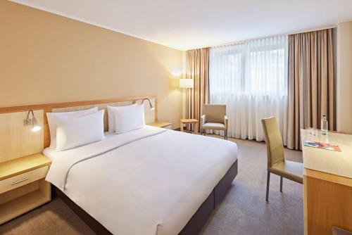 a large white bed in a hotel room at Lindner Hotel Cologne Am Dom, part of JdV by Hyatt in Cologne