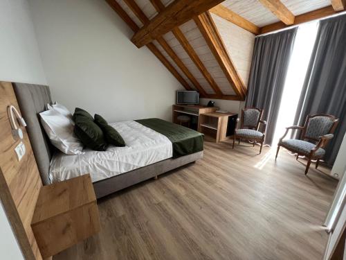 a bedroom with a bed and a desk and chairs at Hotel Le Postillon in Echternach
