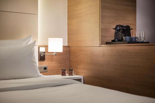 a bedroom with a bed and a coffee maker on a wall at Lindner Hotel Dusseldorf Airport, part of JdV by Hyatt in Düsseldorf