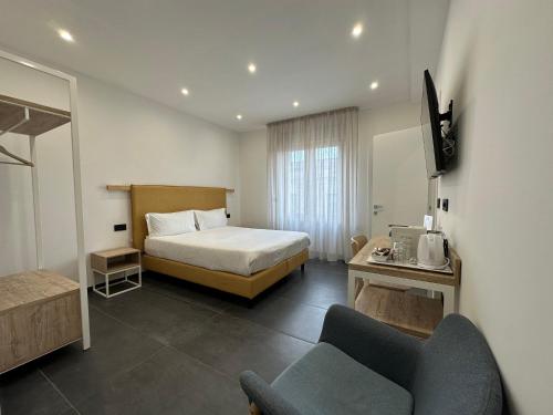 um quarto de hotel com uma cama e uma cadeira em NG Guest House il Gallura em Olbia