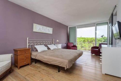 a bedroom with a bed and a couch and a tv at HHBCN Beach apartment Gava #1 in Gavà