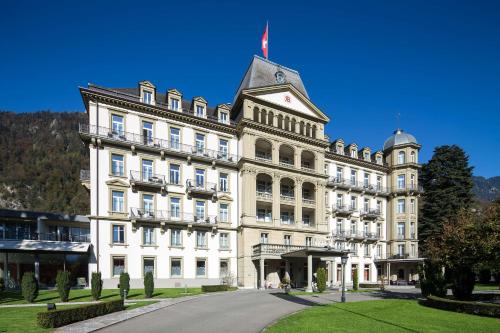 a large white building with a flag on top of it at Grand Hotel Beau Rivage Interlaken in Interlaken