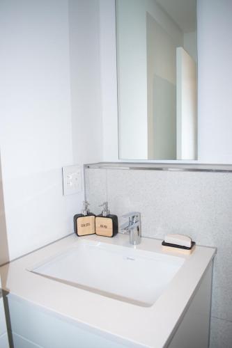 a bathroom with a white sink and a mirror at 101 Bridgewater Apartment in Cape Town