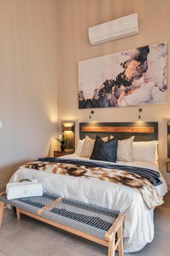 a bedroom with a large bed and a painting on the wall at Summer PALACE Guesthouse in Bloemfontein