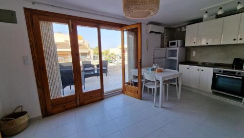une cuisine avec une table et une porte donnant sur une terrasse. dans l'établissement Sunny apartment, à Torrevieja