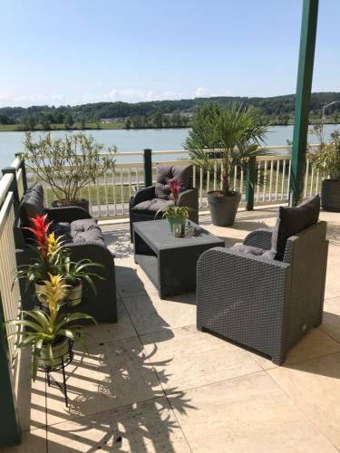 a group of chairs sitting on a patio with a view of the water at Johnys Jungle in Marbach an der Donau
