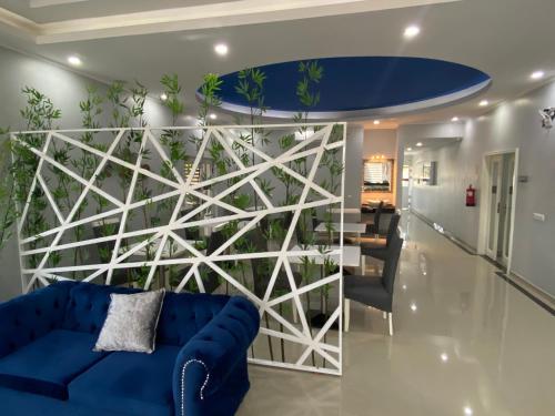 a living room with a blue couch and a wall with plants at TETE PALM HOTEL in Vila-de-Santiago-Maior