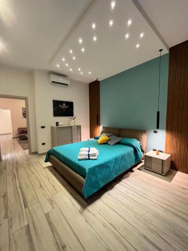 ein Schlafzimmer mit einem großen Bett mit einer blauen Decke in der Unterkunft Pergamena Bianca in Cava deʼ Tirreni