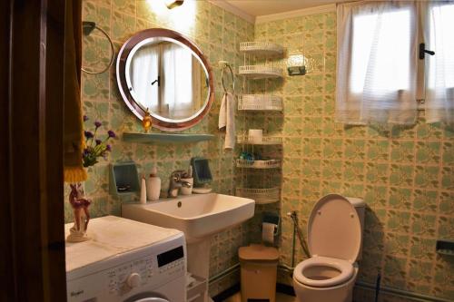 een badkamer met een wastafel, een toilet en een spiegel bij Nautical Nook in Aegina Town