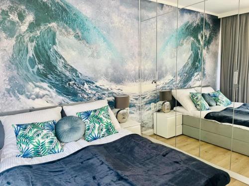a bedroom with a large wave mural on the wall at HO!HOUSE 25 Shellter Rogowo in Rogowo
