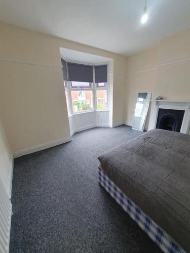 a large bedroom with a bed and a fireplace at 2 bedroom house - Hopefield Road in Leicester