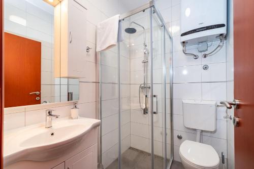 a bathroom with a shower and a sink and a toilet at Apartments Sandra in Turanj