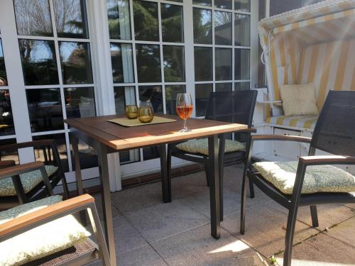 - une table et des chaises sur une terrasse couverte avec un verre de vin dans l'établissement Blue-HideAway, à Bojendorf