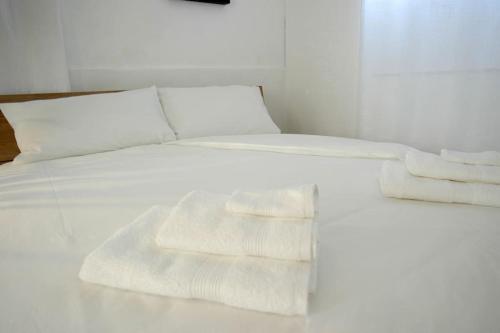 a bed with white sheets and towels on it at Corte Della Filanda Eco-design, Sesto San Giovanni in Sesto San Giovanni